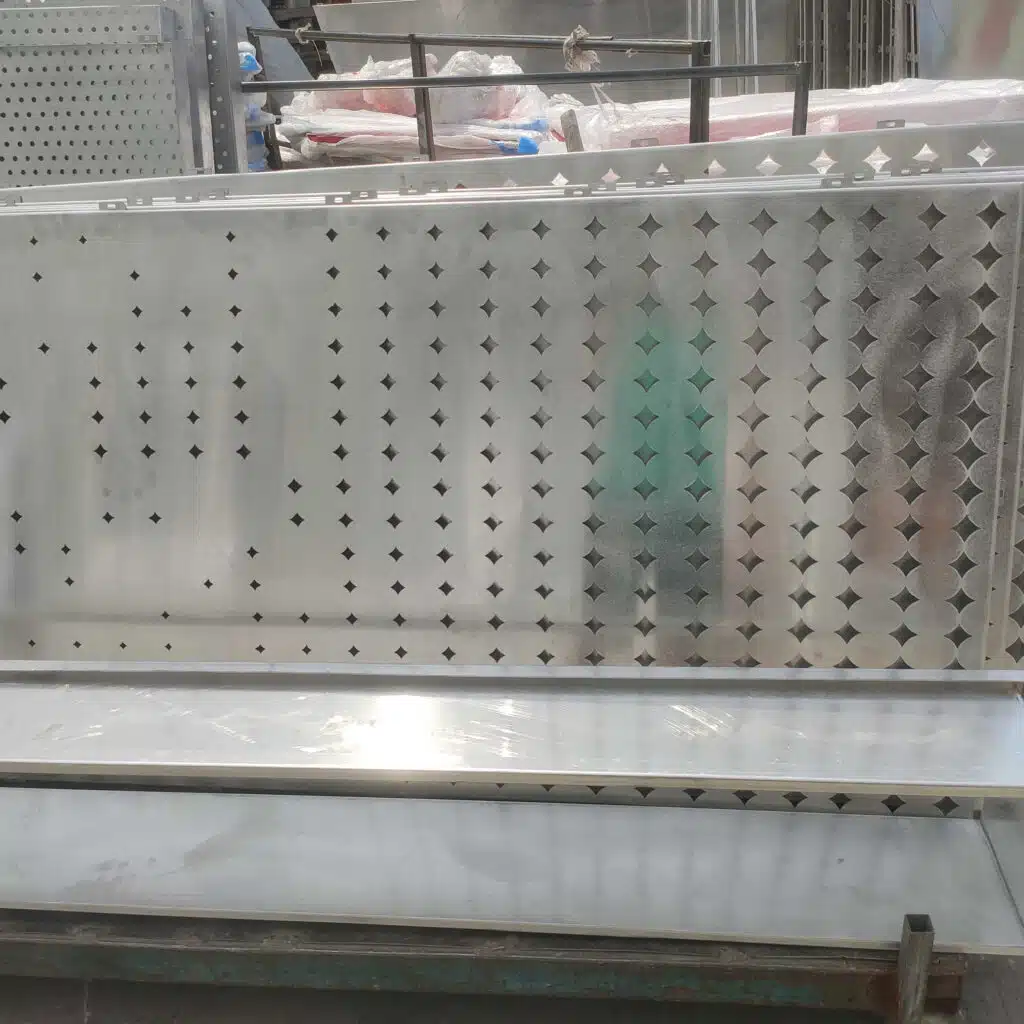 Перфорированные алюминиевые облицовочные панели на заводе Meterny, готовые к нанесению покрытия. Эти панели, вырезанные лазером, имеют уникальный дизайн перфорации для архитектурных фасадов.